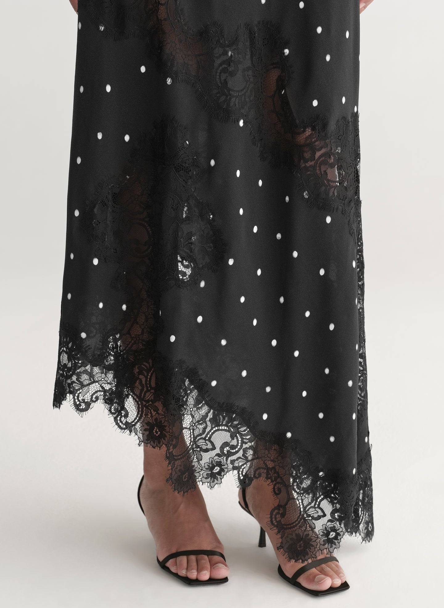 Woman wearing a black polka dot dress on a white background
