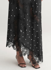 Woman wearing a black polka dot dress on a white background