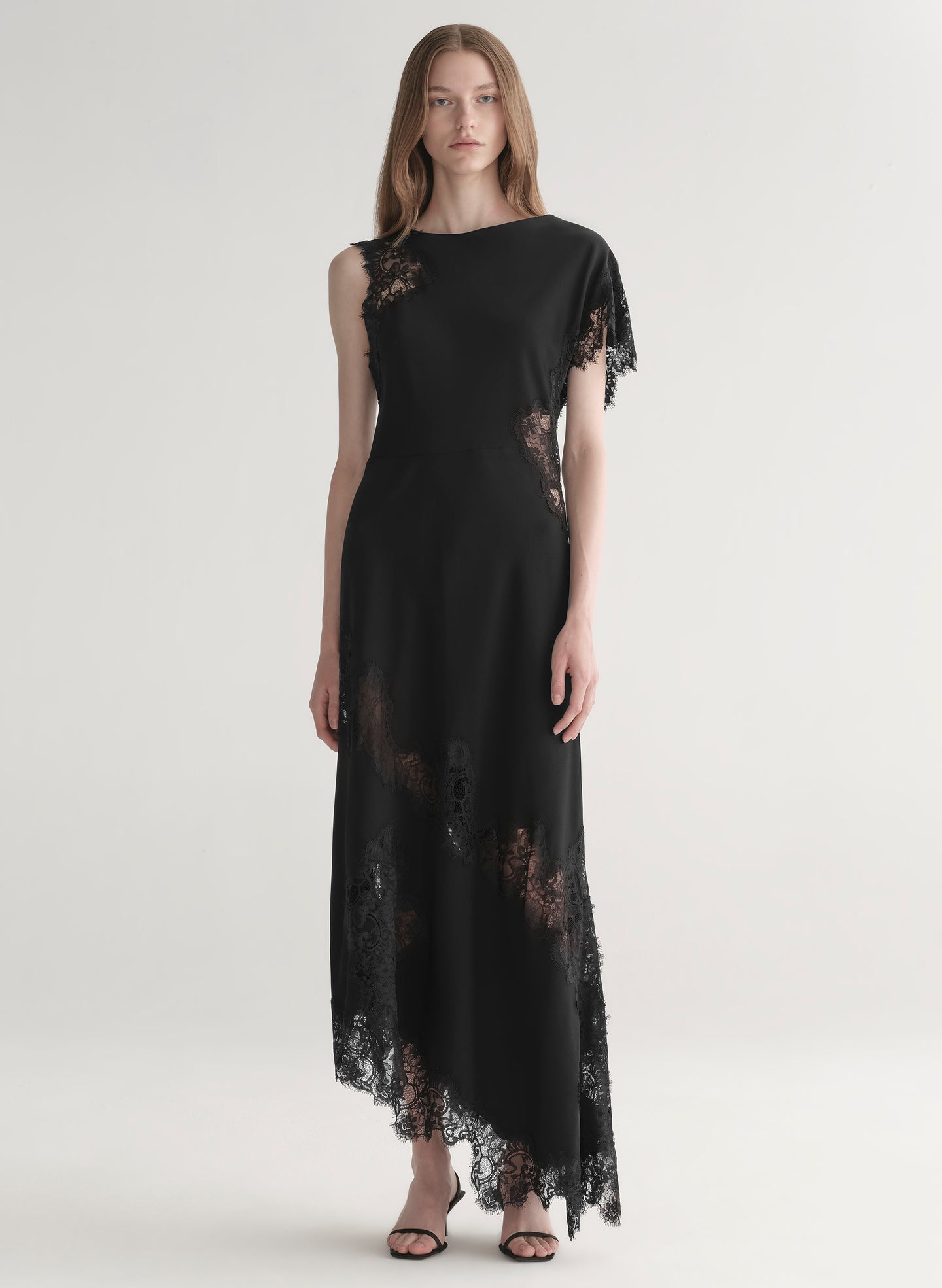 Black lace dress worn by a model on a white background