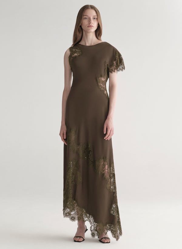 Woman wearing an olive green evening gown with lace details on a white background