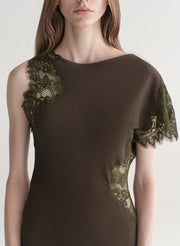 Woman wearing an olive green evening gown with lace details on a white background