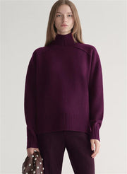 Woman wearing a purple sweater against a plain background