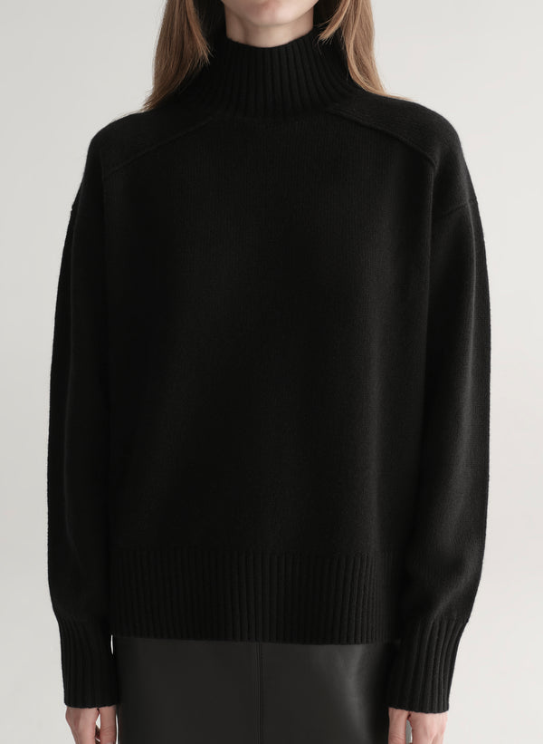 woman wearing black sweater and black leather midi skirt