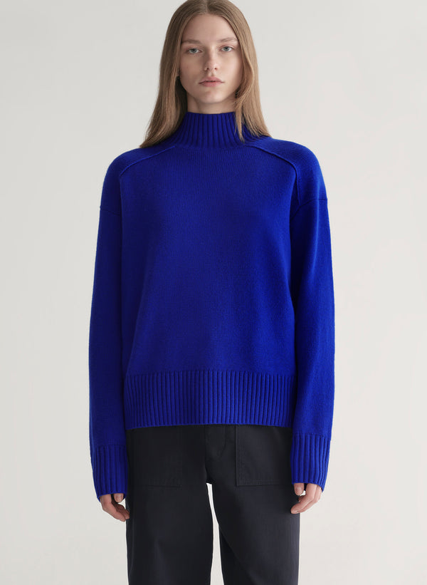 woman wearing bright blue cashmere turtleneck sweater