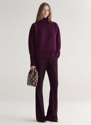 Woman wearing a purple sweater against a plain background