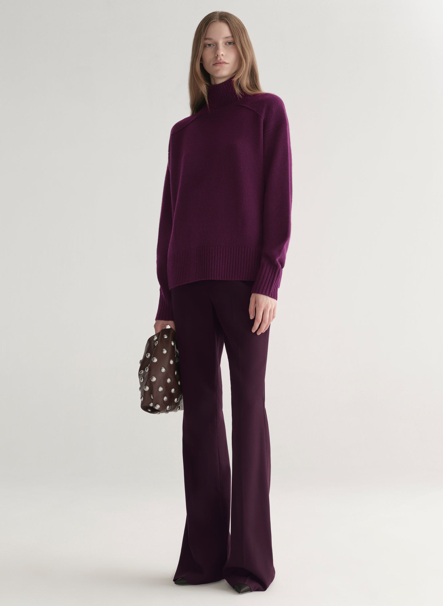 Woman wearing a purple sweater against a plain background