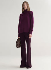 Woman wearing a purple sweater against a plain background