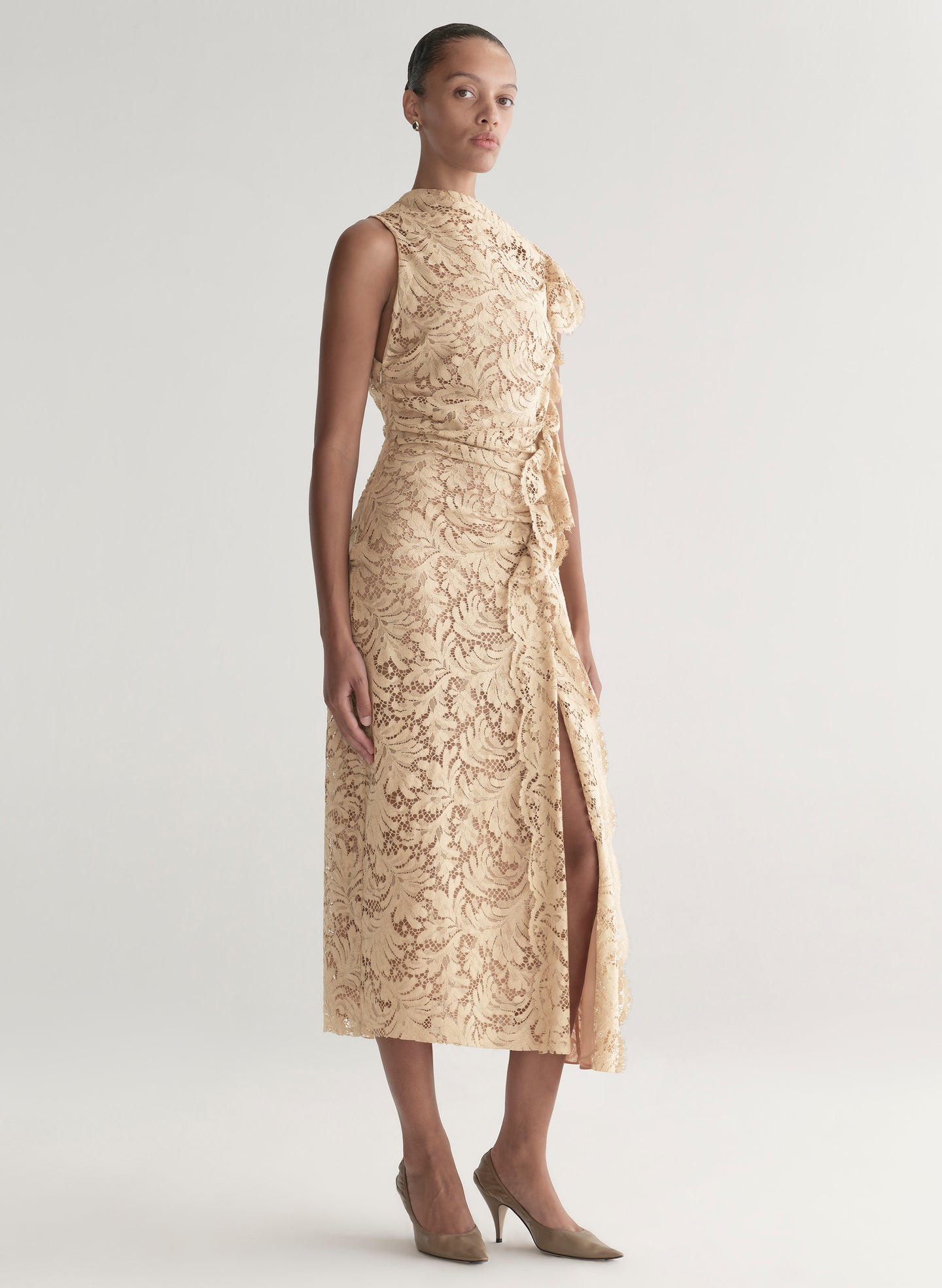 Woman wearing a beige lace dress on a white background