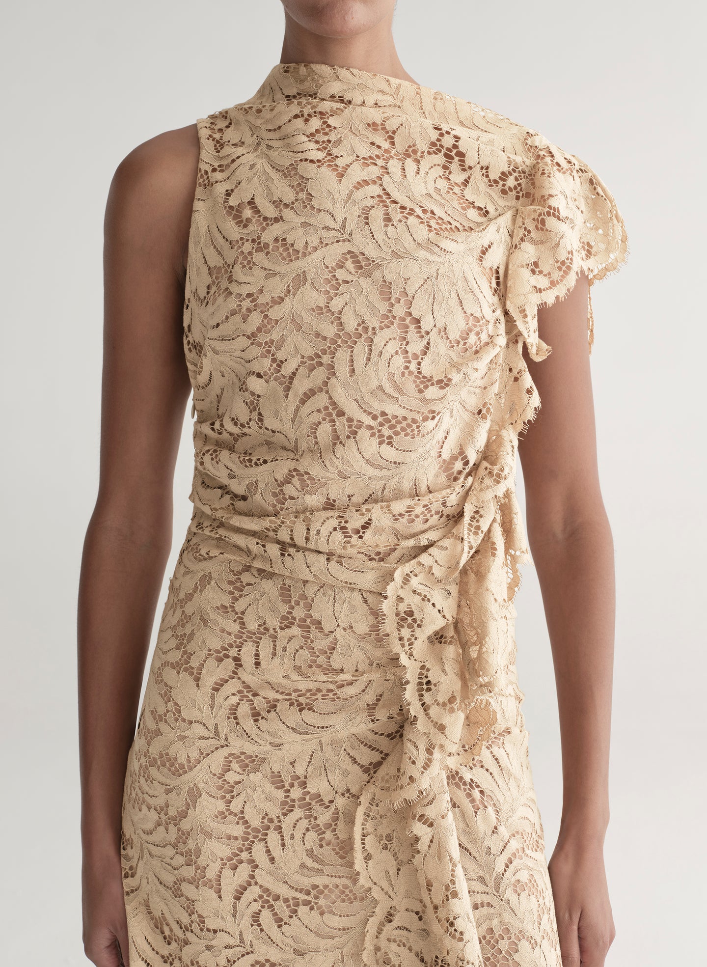 Woman wearing a beige lace dress on a white background