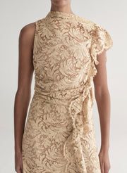 Woman wearing a beige lace dress on a white background
