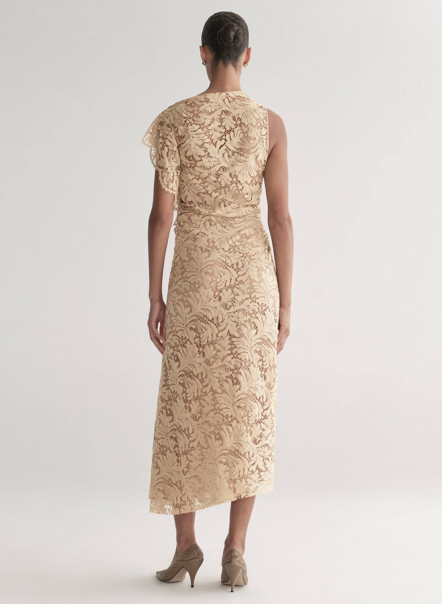 Woman wearing a beige lace dress on a white background
