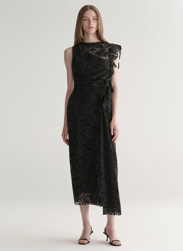 Model wearing a black lace dress on a white background