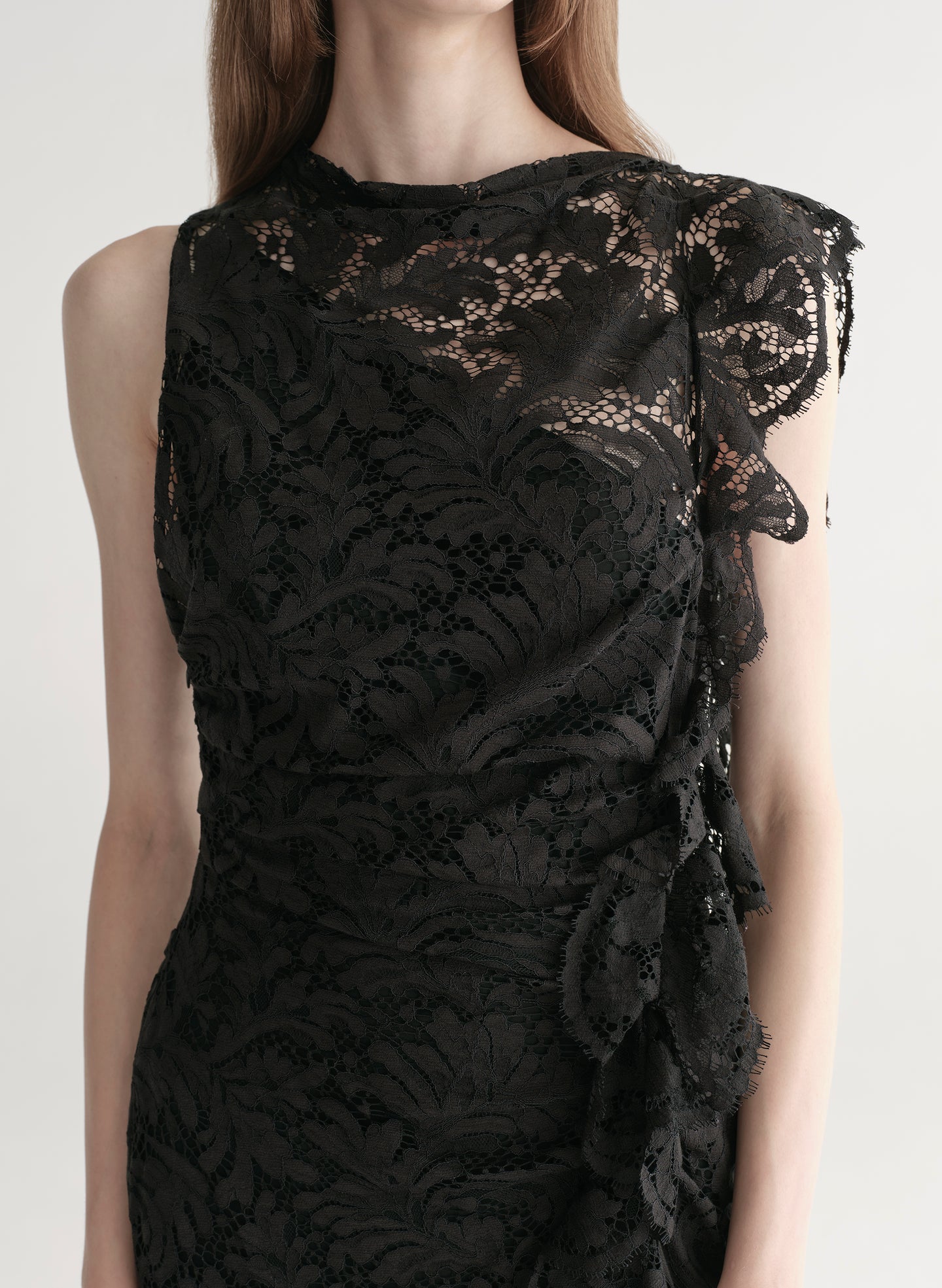 Model wearing a black lace dress on a white background