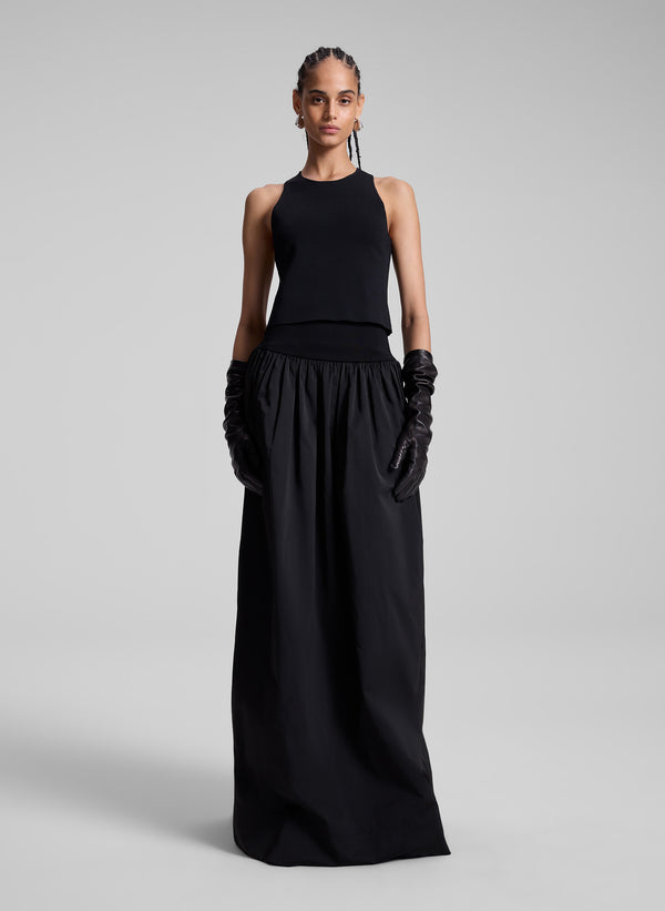 woman wearing black sleeveless top and black maxi skirt and black leather gloves