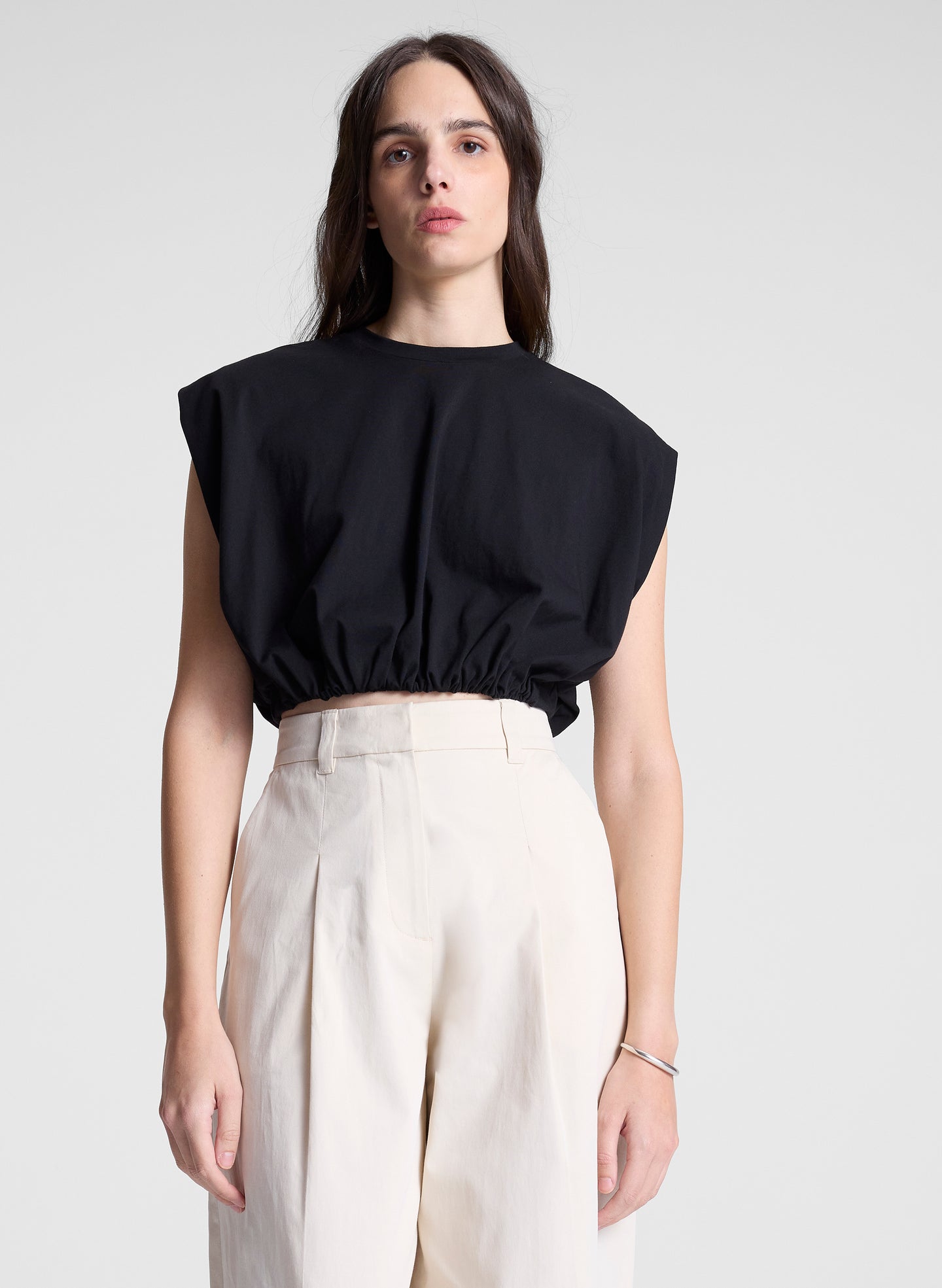 woman wearing black cropped tee and beige pants