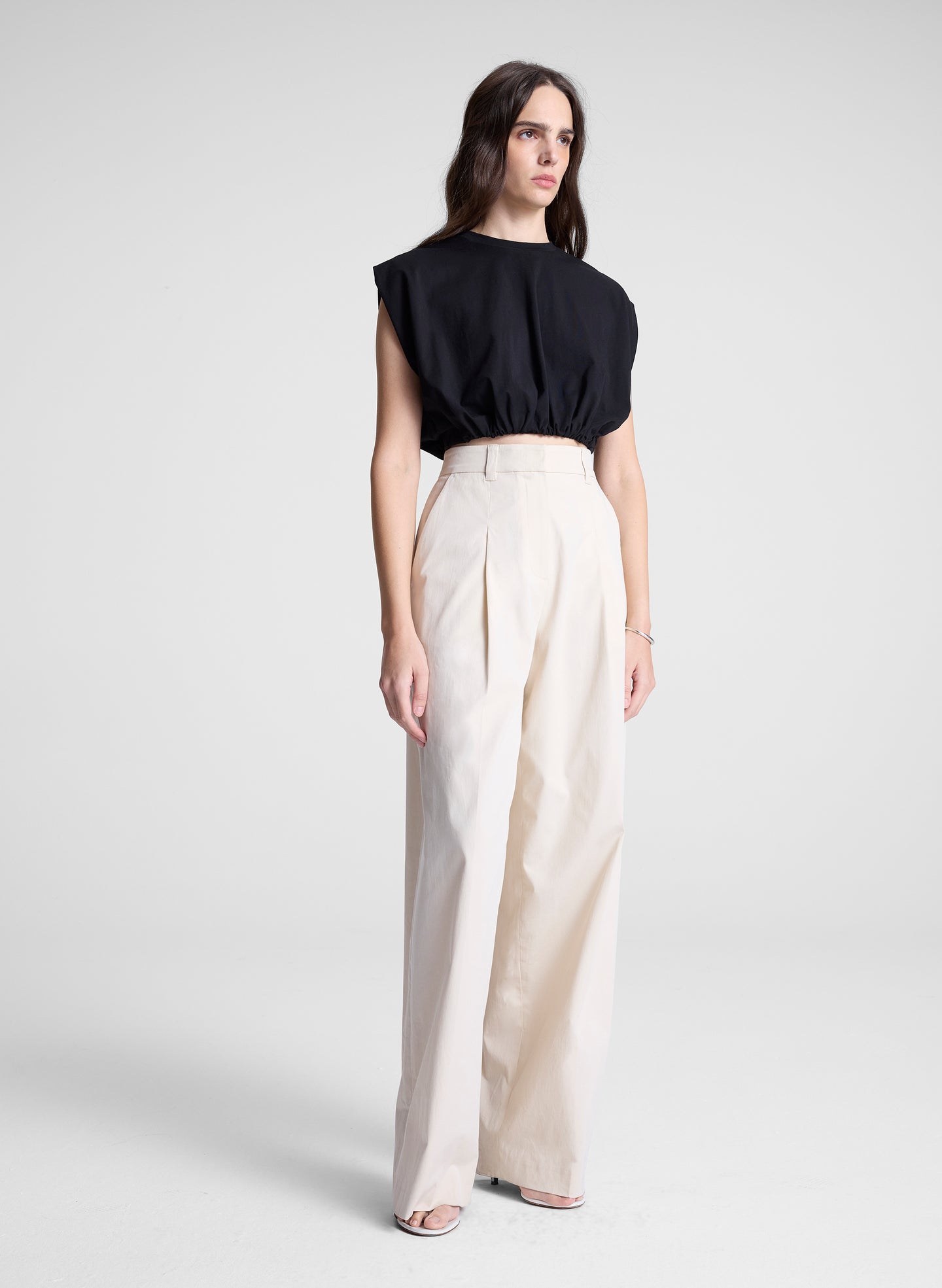 woman wearing black cropped tee and beige pants
