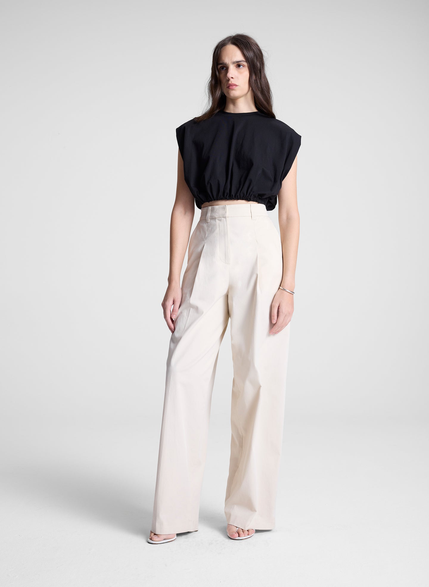 woman wearing black cropped tee and beige pants