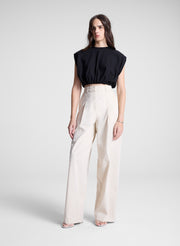 woman wearing black cropped tee and beige pants