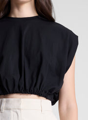 woman wearing black cropped tee and beige pants