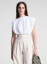 woman wearing white cropped tee and beige pants