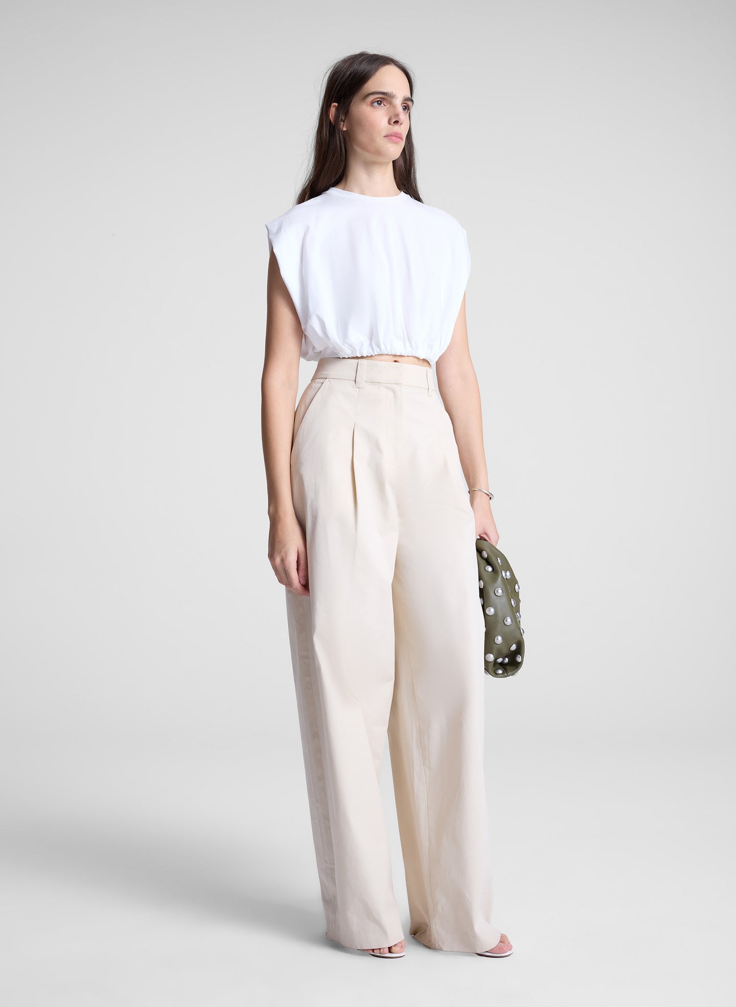 woman wearing white cropped tee and beige pants