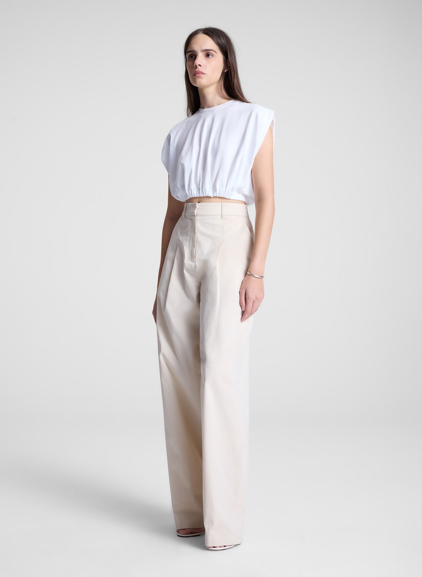 woman wearing white cropped tee and beige pants