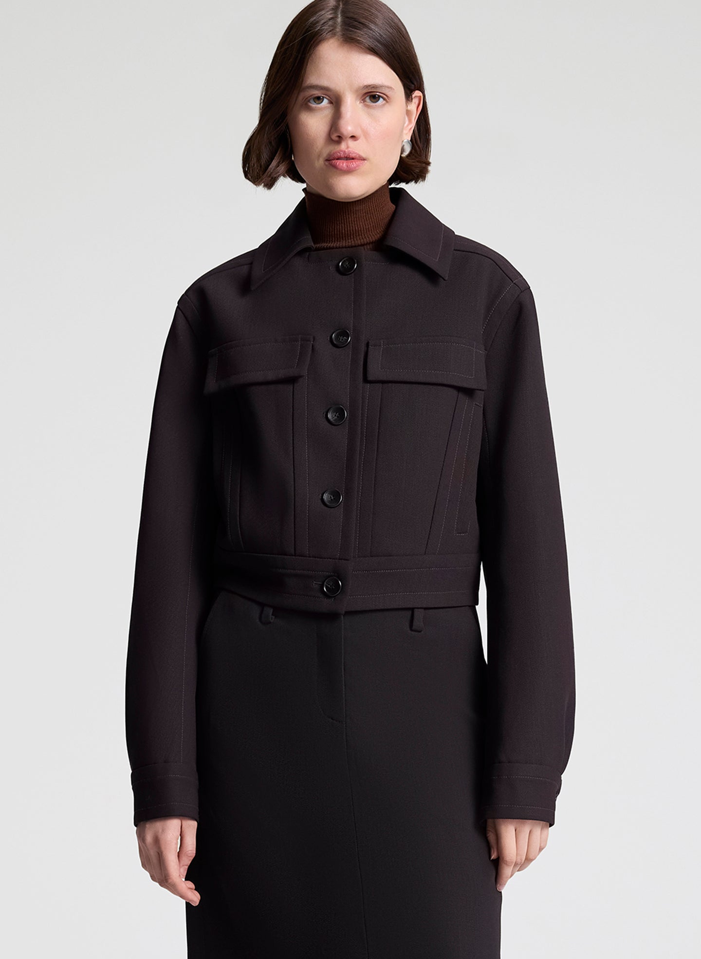 woman wearing dark brown jacket and matching skirt