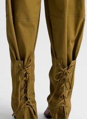 woman wearing white fine gauge voile knit tank top and green pants with tie tapering detail