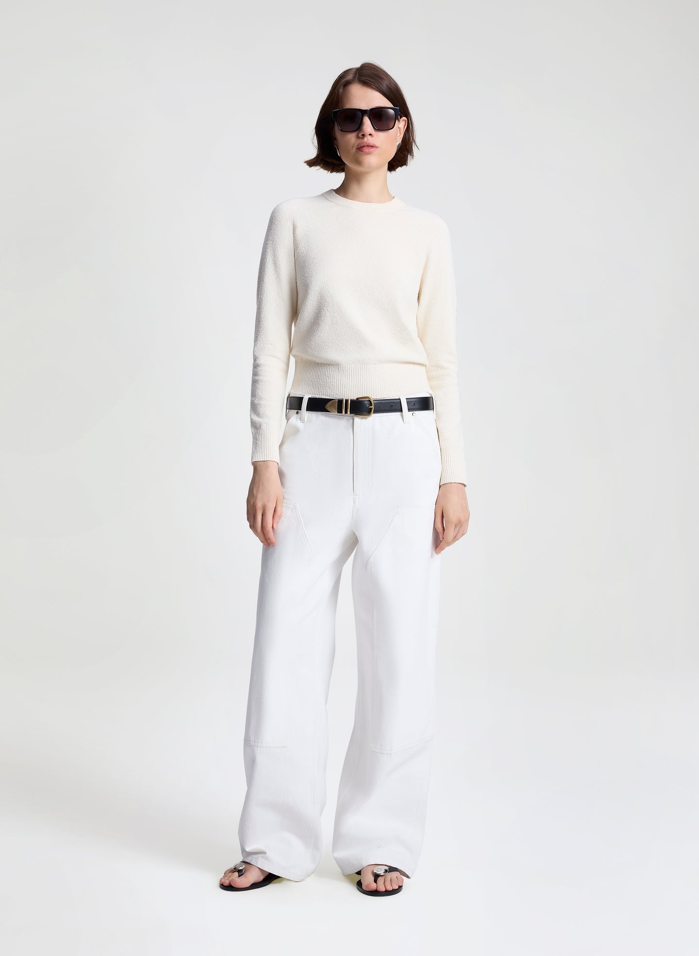 woman wearing off white sweater and white denim jeans
