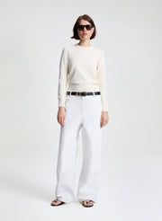 woman wearing off white sweater and white denim jeans