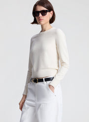 woman wearing off white sweater and white denim jeans