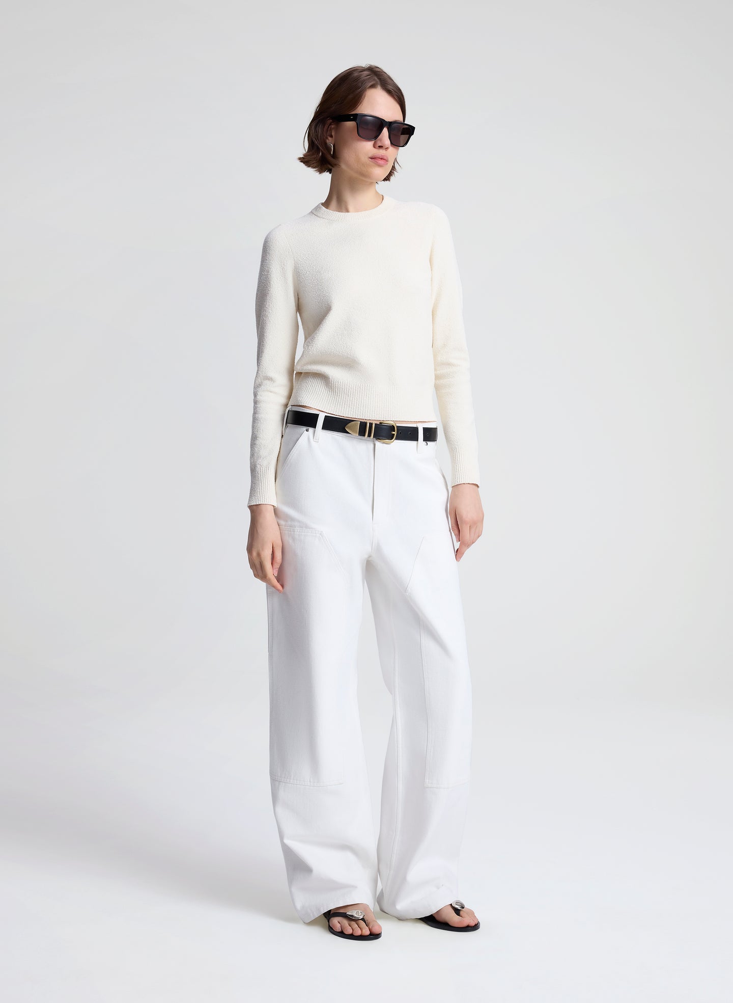 woman wearing off white sweater and white denim jeans