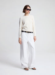 woman wearing off white sweater and white denim jeans