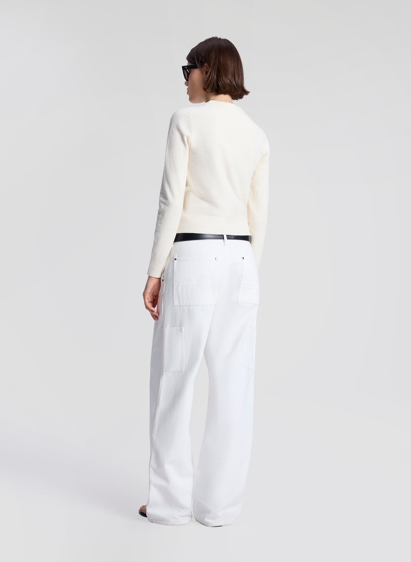 woman wearing off white sweater and white denim jeans