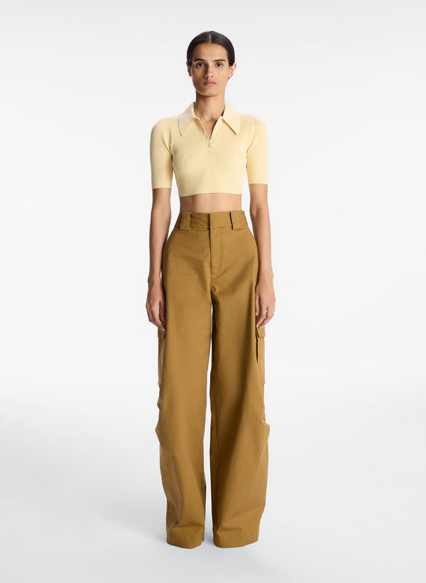 front view of woman wearing yellow cropped collared shirt and tan cargo pants
