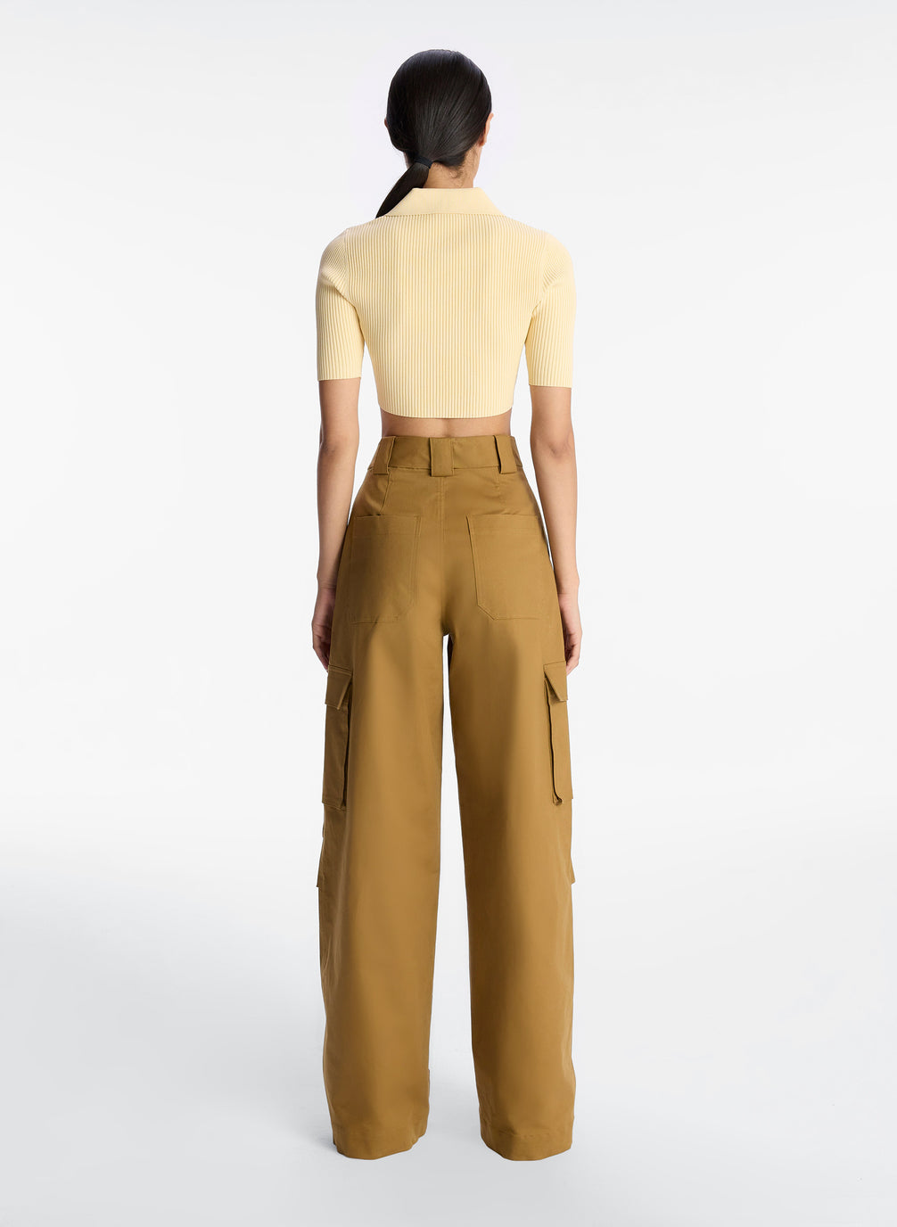 back view of woman wearing yellow cropped collared shirt and tan cargo pants