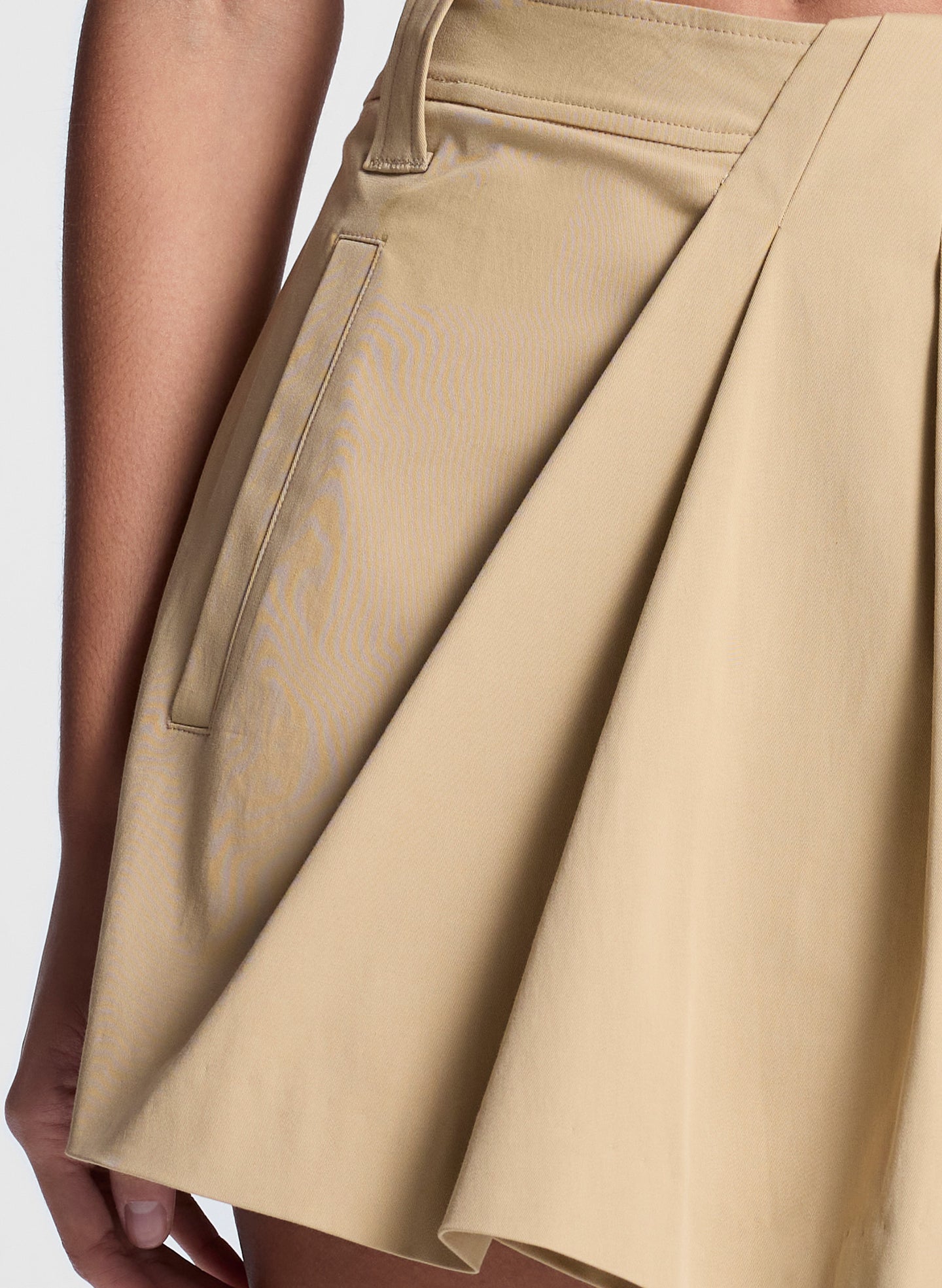 woman wearing white fine gauge voile knit top and tan skort shorts