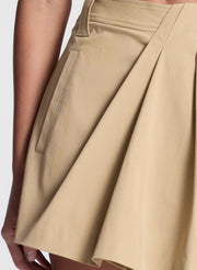 woman wearing white fine gauge voile knit top and tan skort shorts