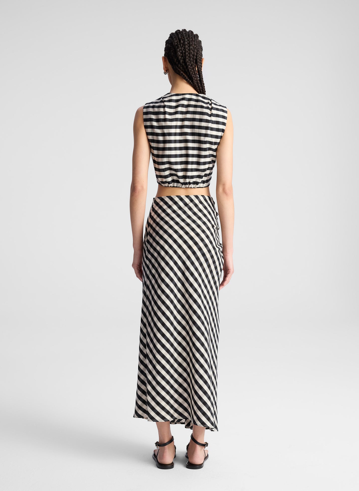 woman wearing black plaid gingham crop top and midi skirt set