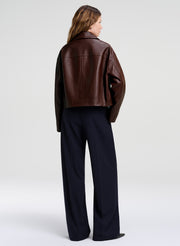 woman wearing brown leather jacket and navy blue wide leg pants
