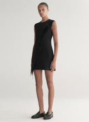 Black sleeveless dress with feather details on a neutral background