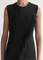 Black sleeveless dress with feather details on a neutral background