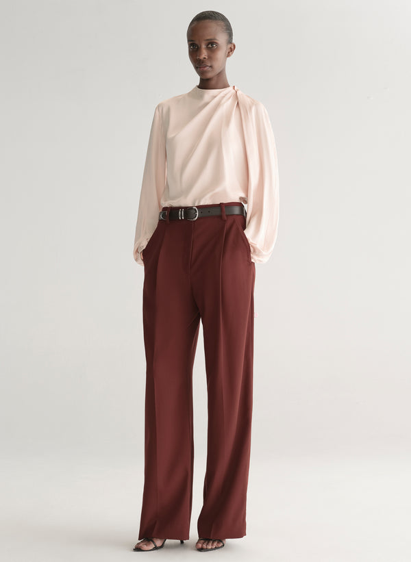 woman wearing pink top and red pants with brown belt