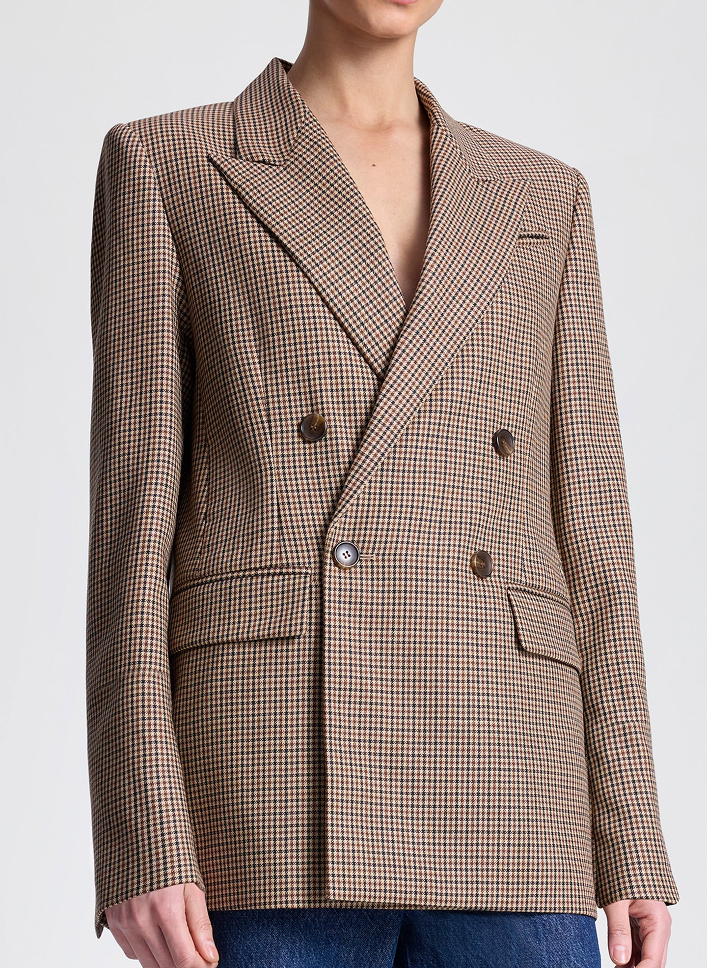 Brown checkered blazer worn by a person on a light gray background