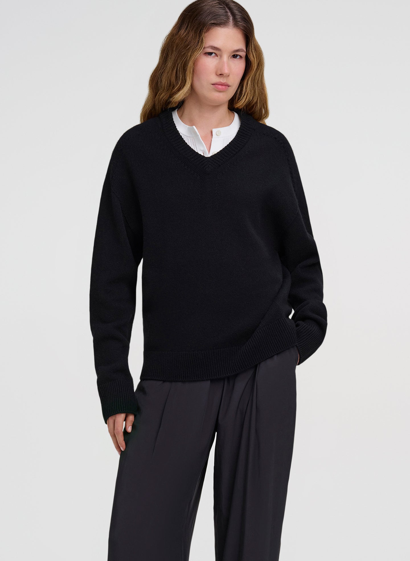 woman wearing white shirt under black sweater with black pants
