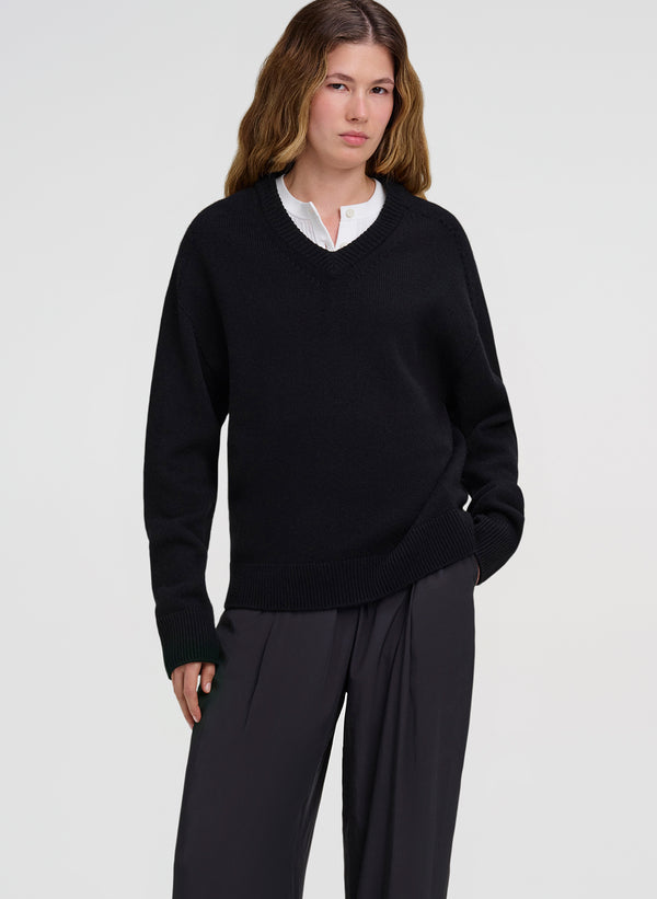 woman wearing white shirt under black sweater with black pants