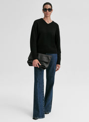 woman wearing black v neck cashmere sweater and blue jeans