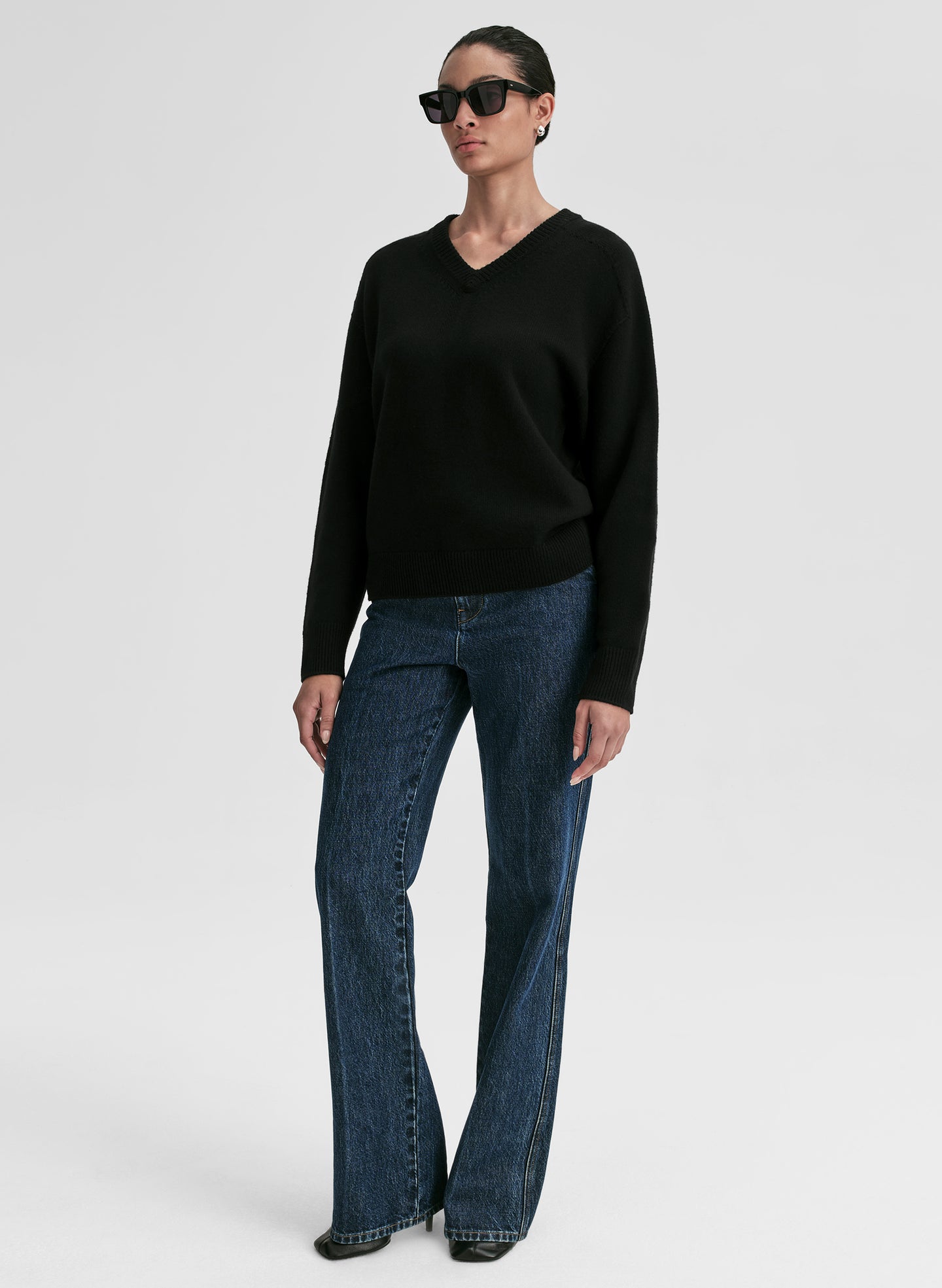 woman wearing black v neck cashmere sweater and blue jeans