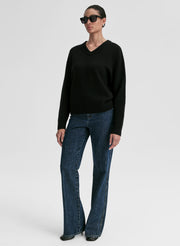 woman wearing black v neck cashmere sweater and blue jeans