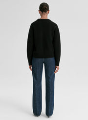 woman wearing black v neck cashmere sweater and blue jeans